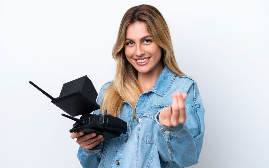 Smiling drone operator holding controller against white background