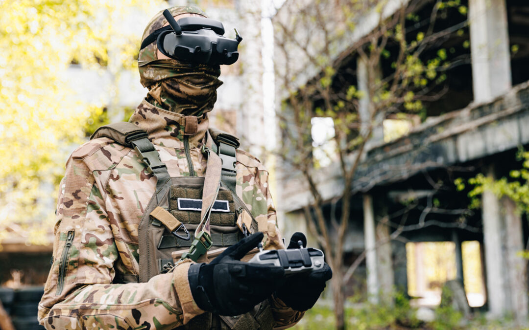 Soldier in camouflage uniform using FPV goggles and a drone controller during military drone operations