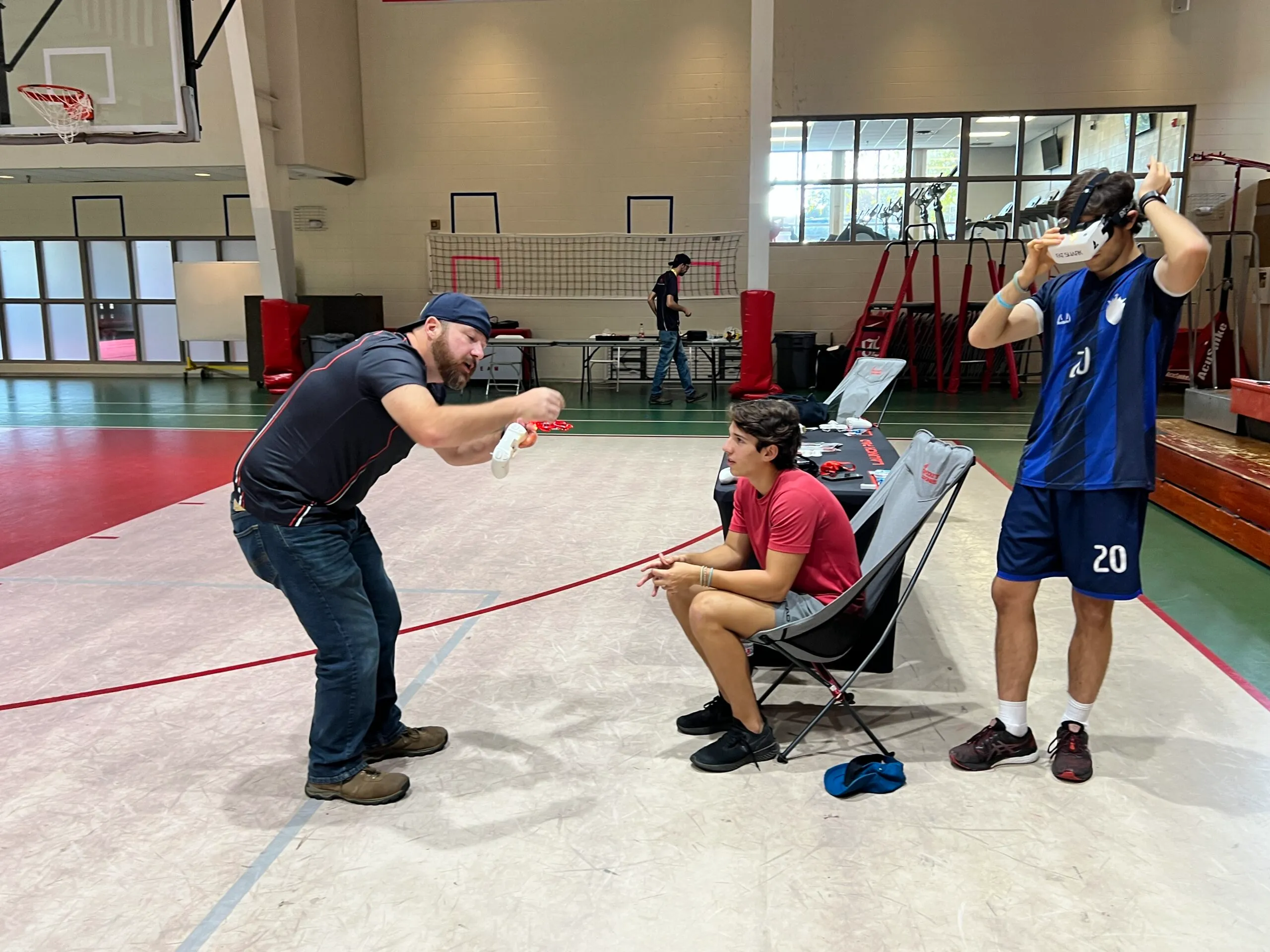 Instructor teaching FPV drone flight to students indoors, demonstrating hands-on drone training for growing career opportunities.