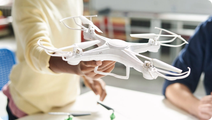 Student holding white drone during Rocket Drones podcast promo shoot about STEM learning