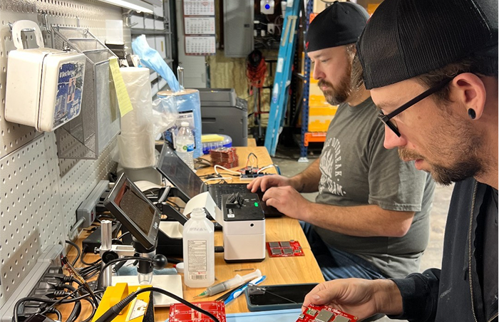 Rocket Drones technicians assembling and testing electronic components for classroom drone STEM kits in the in-house production lab.