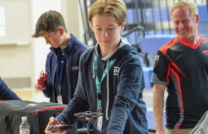 Students and instructor participating in a Rocket Drones classroom session, testing drones and sharing real-time feedback to improve STEM training products.